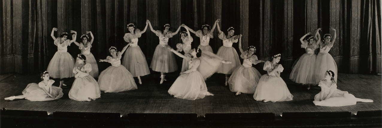 Photograph of ballet dancers posing on stage.